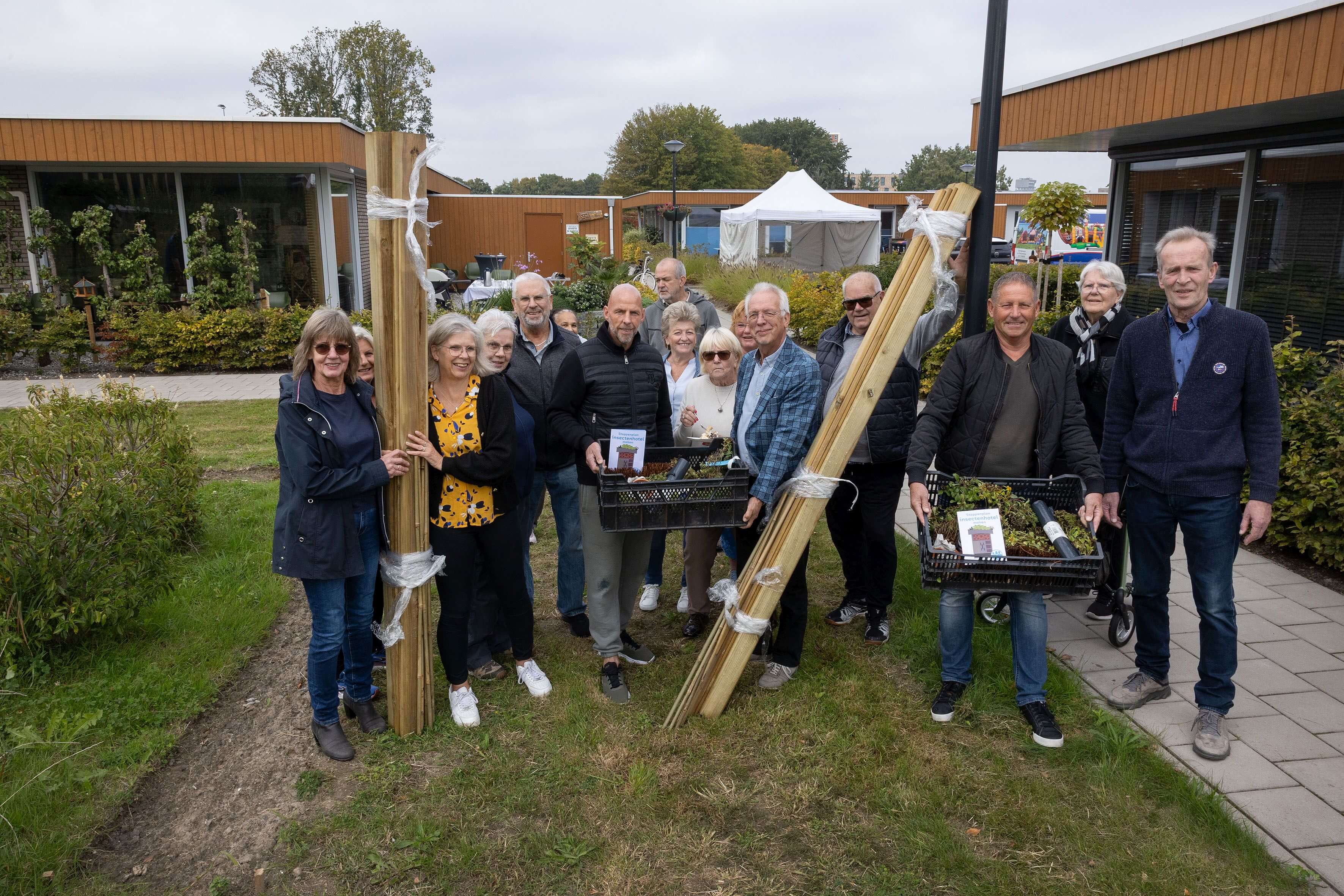 Wethouder Sjaak Kruis overhandigt de eerste twee doe-het-zelf insectenhotelpakketten. Foto: fotostudio Wierd.
