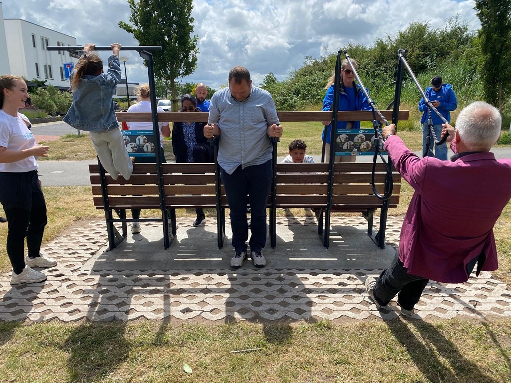 Inwoners doen oefeningen bij een beweegbank