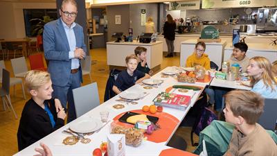 Kinderen en wethouder Dennis Grimbergen aan het ontbijt