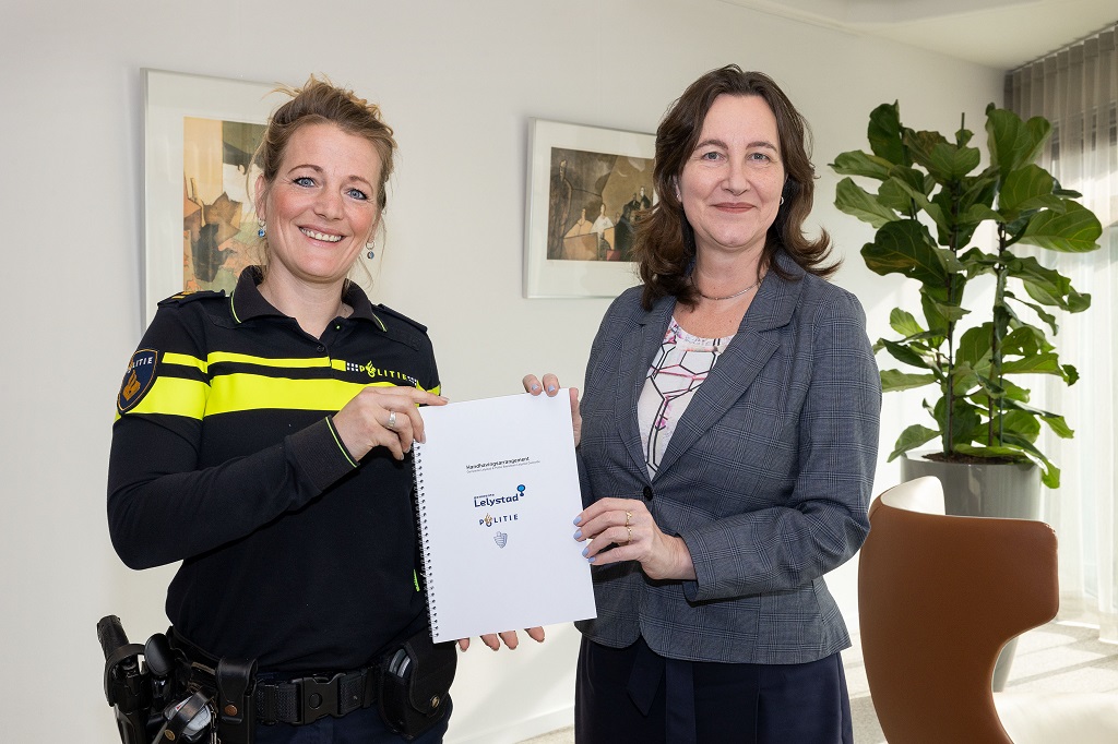 Teamchef Joanneke Schmidt van basisteam Lelystad-Zeewolde (links) en burgemeester Mieke Baltus met het door hen ondertekende handhavingsarrangement. Ronald de Kruijk, officier bij het Openbaar Ministerie, heeft eveneens getekend maar ontbreekt op de foto.
