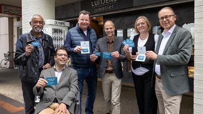 Wethouder Dennis Grimbergen neemt de eerste hernieuwde Lelypas van de Stichting Lelypas in ontvangst