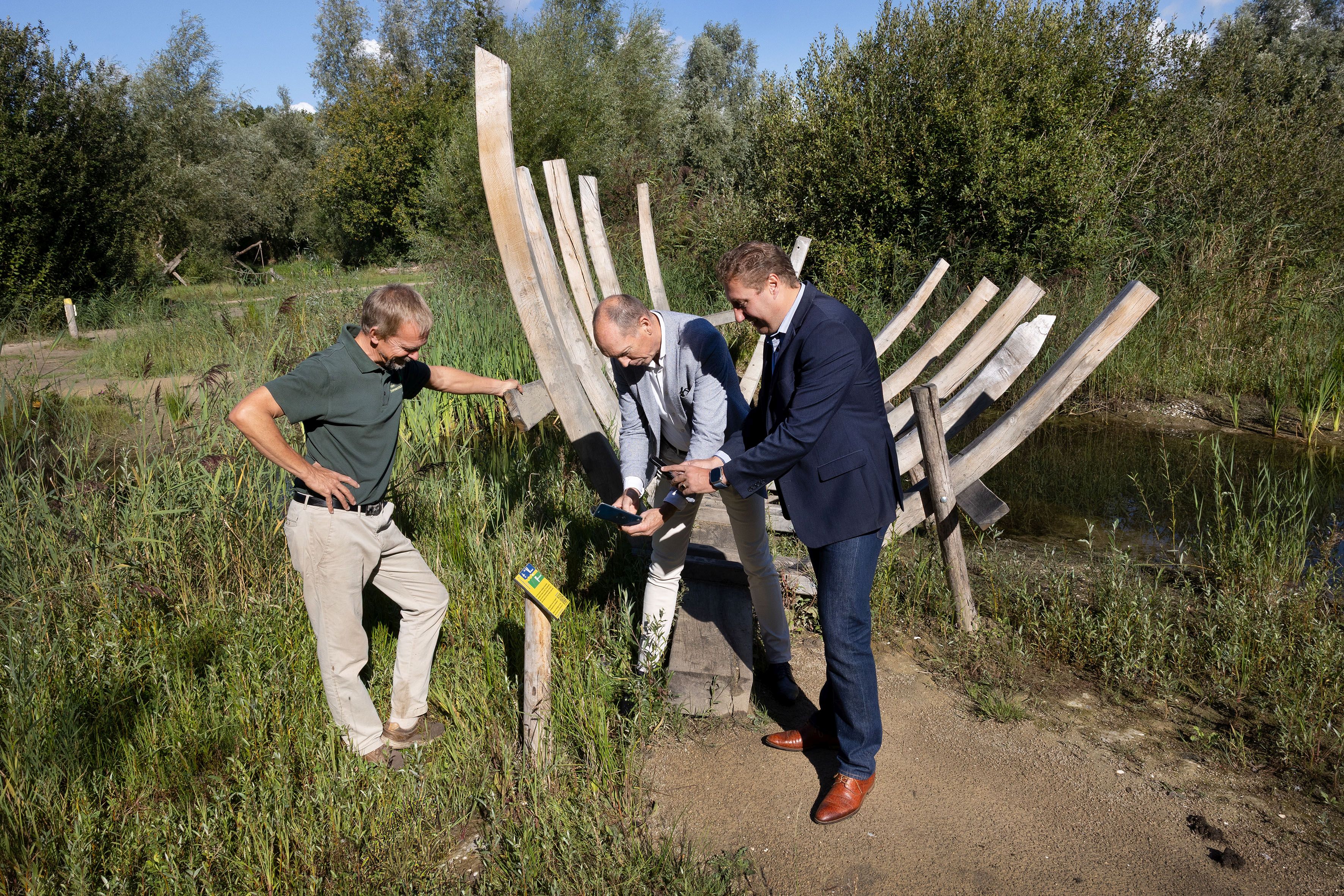 Voorzitter van Stichting Het Belevenissenbos André Rijsdorp, gedeputeerde Harold Hofstra en wethouder Piet van Dijk in het belevenissenbos.