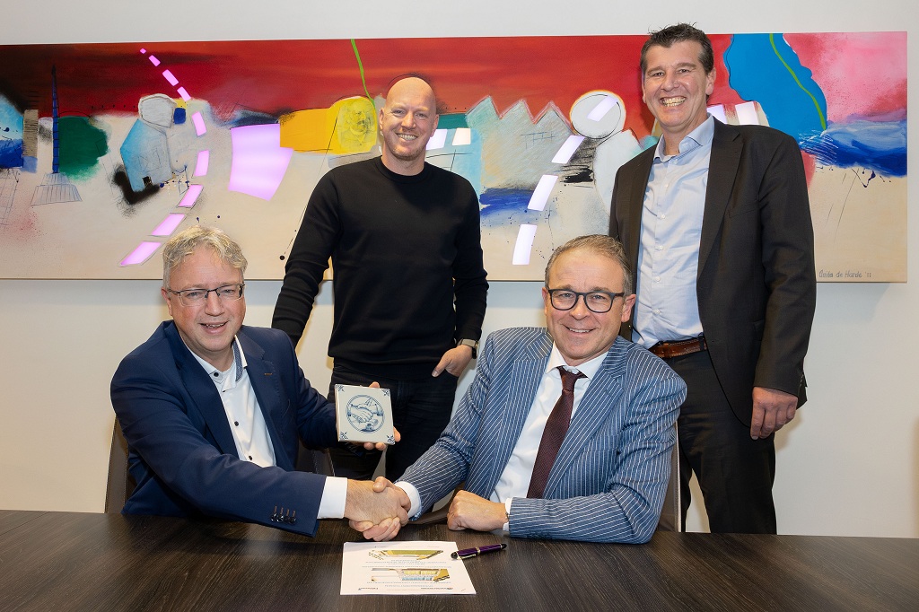 Wethouder Dennis Grimbergen en directeur Dirk Jan de Rouwe schudden elkaar de hand na de ondertekening van het contract. Achter hen staan directeur-bestuurder Bas Iliohan van Porteum en directeur Eelco Derks van Sportbedrijf Lelystad