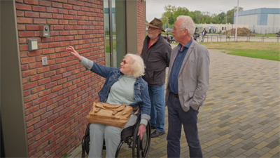 Still uit de video. Margriet Doorenspleet, voorzitter werkgroep toegankelijkheid van het GOL en Paul van der Heijden, bouwkundig lid van de werkgroep namen wethouder Kruis mee naar Porteum.