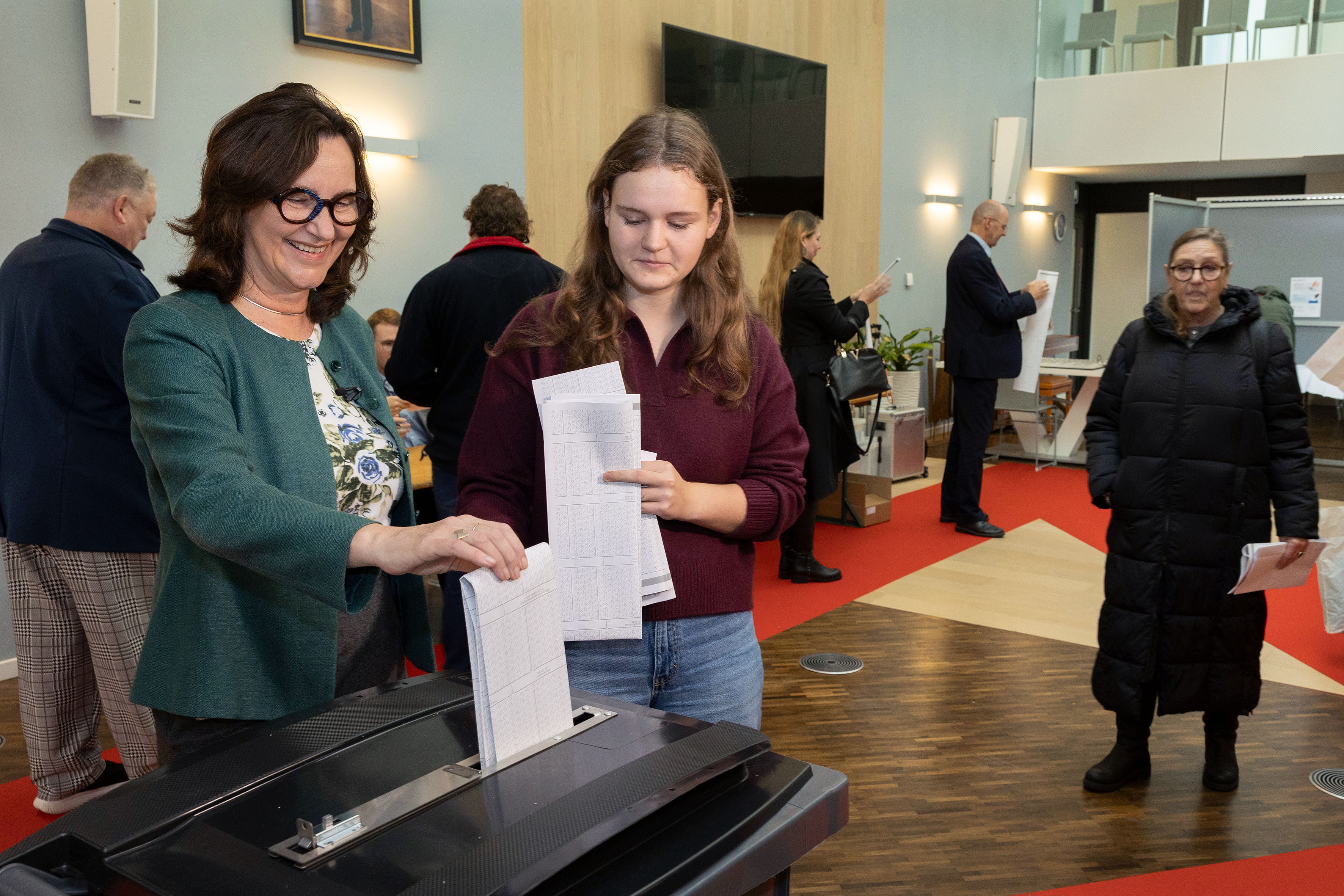 Burgemeester Mieke Baltus en jonge nieuwe kiezer Nynke brengen hun stem uit in het stadhuis
