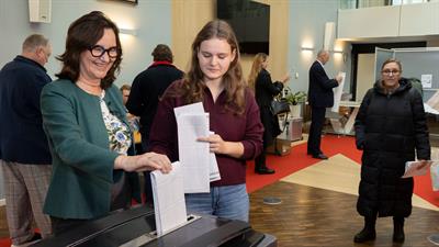 Burgemeester Mieke Baltus en jonge nieuwe kiezer Nynke brengen hun stem uit in het stadhuis
