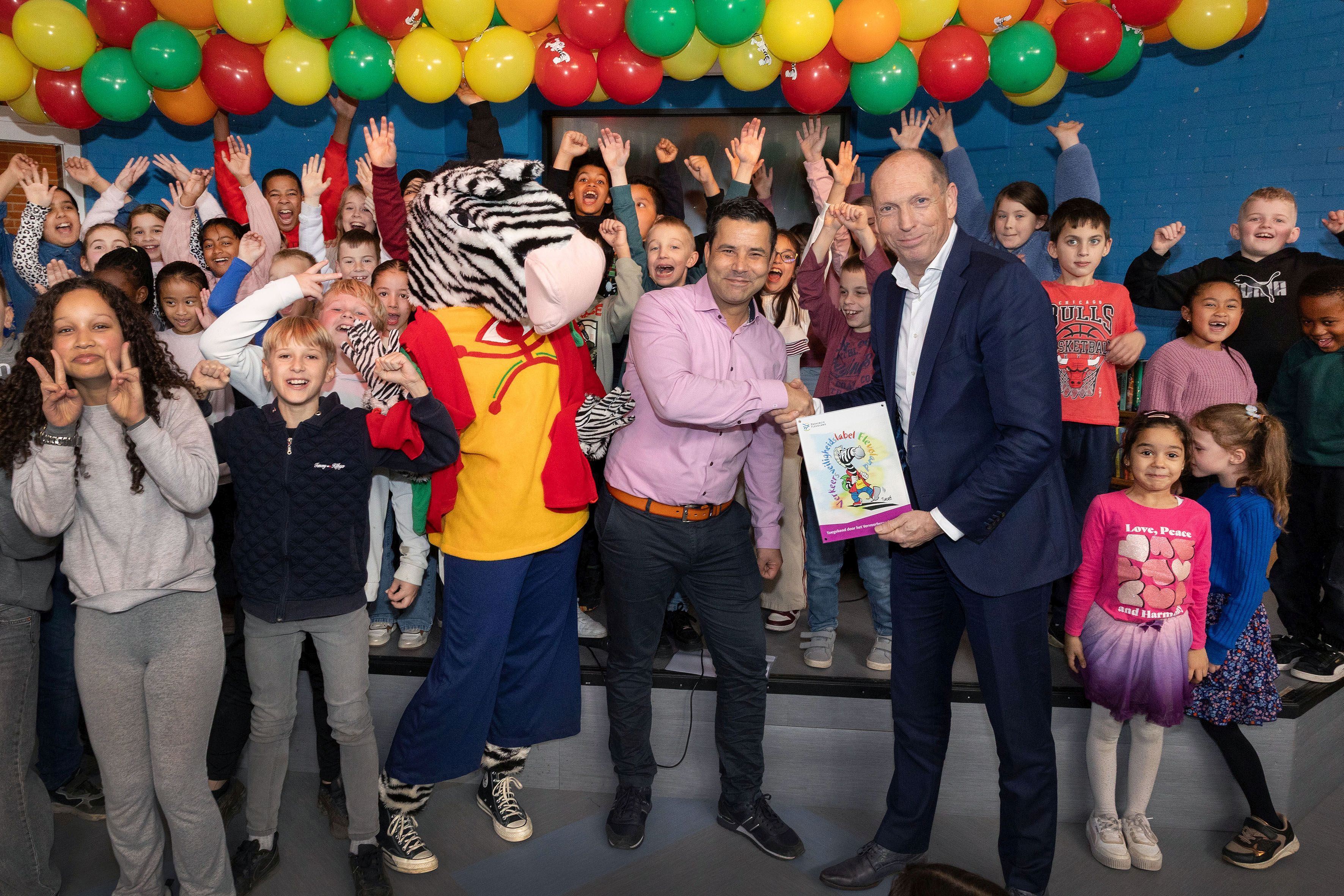 Directeur Rachid Yahyaoui ontving namens basisschool De Lepelaar het Verkeersveiligheidslabel Flevoland uit handen van wethouder Piet van Dijk.