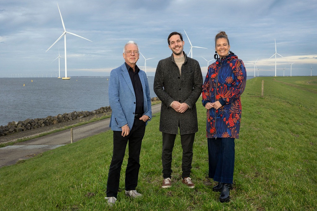 Wethouder Sjaak Kruis, O&amp;M-manager Johann Kaemingk van Vattenfall en de Drontense wethouder Lazise Hillebregt op de dijk met windmolens van Windplanblauw op de achtergrond