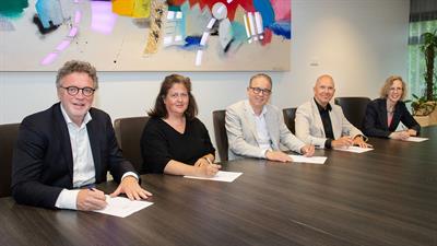 Joost Meijs (Coloriet), Cindy Netten (Medrie), wethouder Dennis Grimbergen (gemeente Lelystad), John Bos (Woonzorg Flevoland) en Martine Visser (Centrada) ondertekenen het convenant