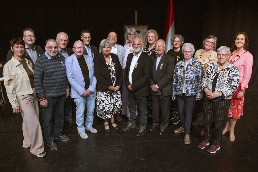 Burgemeester Mieke Baltus met de zestien Lelystedelingen die een koninklijke onderscheiding hebben ontvangen