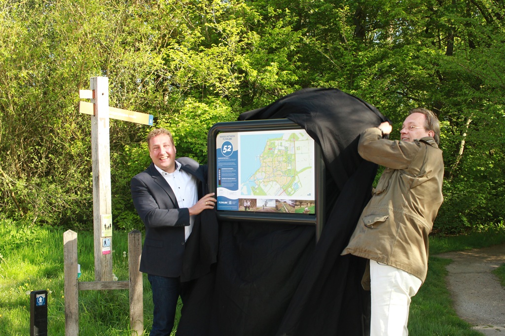Wethouder Jan-Nico Appelman (rechts) en gedeputeerde Harold Hofstra onthullen het overzichtsbord van het wandelnetwerk in het Zuigerplasbos