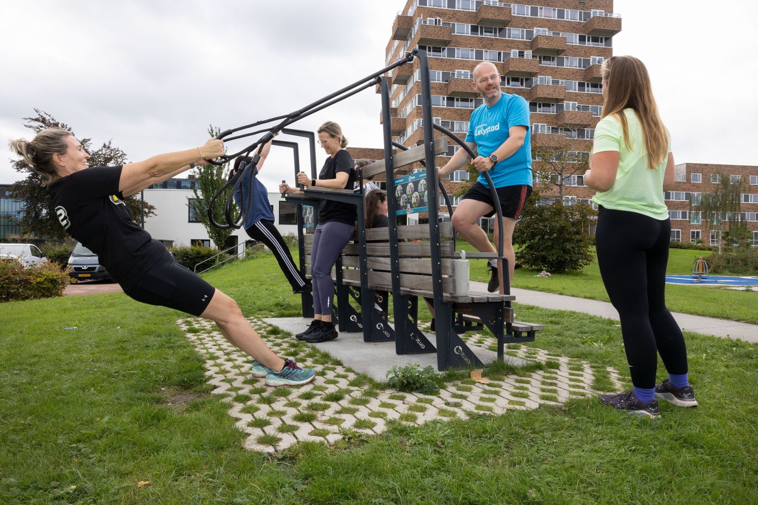 De deelnemers van de sportles samen met wethouder Bakelaar (in het blauw rechts) in actie op 14 september bij de beweegbank Hanzeborg onder leiding van FIT12