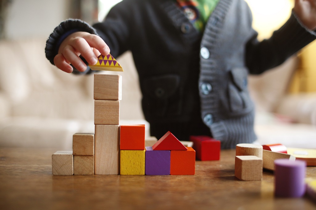 Kind die blokken bouwwt