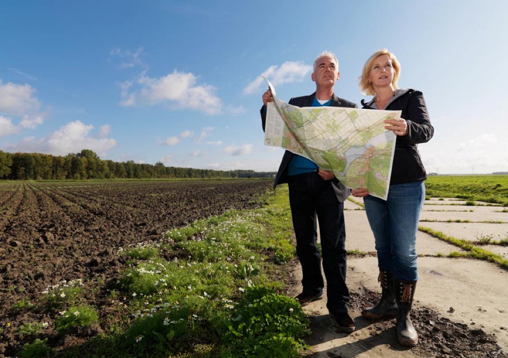 Man en vrouw met kaart in weiland